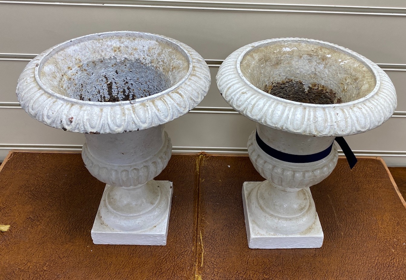 A pair of Victorian cast iron campana shaped garden urns, diameter 24cm, height 30cm